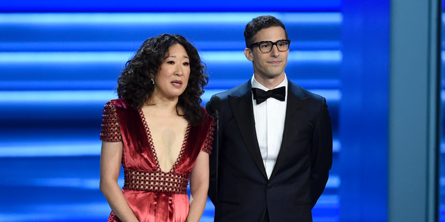 Sandra Oh, left, and Andy Samberg present an award at the 70th Primetime Emmy Awards in Los Angeles. Oh and Samberg will share host duties at next month’s Golden Globe ceremony. 