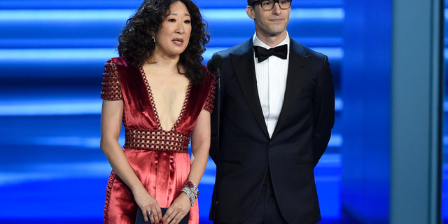 Sandra Oh, left, and Andy Samberg present an award at the 70th Primetime Emmy Awards in Los Angeles. Oh and Samberg will share host duties at next month’s Golden Globe ceremony.