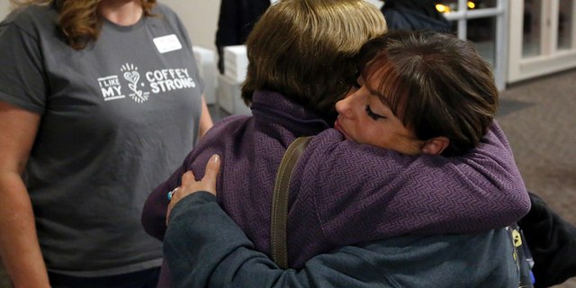 In this photo taken Tuesday, Dec. 11, 2018, Camp Fire survivor Terese Mangino, right, embraces Tubbs Fire survivor Anne Barbour as fellow survivor Tricia Woods, left, looks on, after a meeting with Camp Fire survivors in Chico, Calif. Survivors of a deadly wildfire that last year tore through California's wine country are sharing lessons of loss and pain but also of resilience with those who last month escaped the deadliest U.S. wildfire in at least a century. The Press Democrat reports a group of Sonoma County residents spent Tuesday in a packed meeting with residents of Paradise and several nearby communities who grilled them with questions. (Alvin Jornada/The Press Democrat via AP)