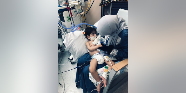 In this Wednesday, Dec. 19, 2018, photo released by the Council on American-Islamic Relations, Sacramento Valley, Shaima Swileh holds her dying 2-year-old son Abdullah at a hospital in Oakland, Calif. Swileh, a Yemeni mother who fought for the right to see her dying son, arrived Wednesday night after the Trump administration gave her a long-sought waiver to its travel ban. (Council on American-Islamic Relations, Sacramento Valley via AP)