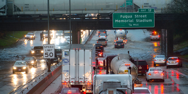 Cars stack up northbound on Interstate 110, as they encounter high water in the roadway under the railroad bridge near the governor's mansion, as even fewer vehicles opt to try to navigate the water as they progress southbound after heavy rains, Thursday, Dec. 27, 2018, in Baton Rouge, La. (Travis Spradling/The Advocate via AP)