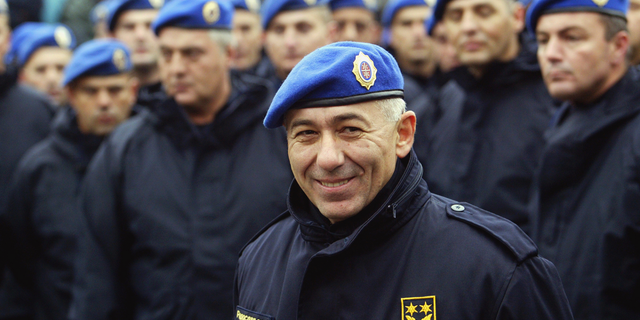 FILE - In this Oct. 24, 2003 file photo, former Serbian police commander Gen. Goran Radosavljevic known as Guri stands in front of Serbia's elite police troops during a protest in Belgrade, Serbia. In a statement Wednesday Dec. 19, 2018, the U.S. State Department linked former Serbian police commander Goran Radosavljevic to the 1999 murder of three Albanian-American brothers and banned him and his family members from entering the United States. (AP Photo/Darko Vojinovic, File)