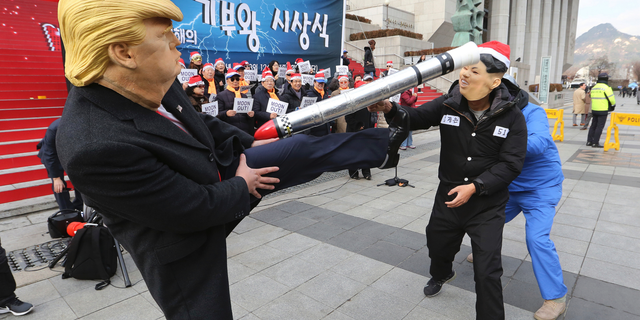 A protester, left, wearing a mask of U.S. President Donald Trump kicks his fellow protester wearing a mask of North Korean leader Kim Jong Un during a rally to denounce policies of South Korean President Moon Jae-in on North Korea in Seoul, South Korea, Tuesday, Dec. 18, 2018. Kim's return visit to Seoul appears unlikely to take place this month, a senior South Korean official said last week. (AP Photo/Ahn Young-joon)