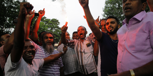 Supporters of ousted Sri Lankan Prime Minister Ranil Wickremesinghe celebrate outside the supreme court complex in Colombo, Sri Lanka, Thursday, Dec. 13, 2018. Sri Lanka's Supreme Court unanimously ruled as unconstitutional President Maithripala Sirisena's order to dissolve Parliament and call for fresh elections, a much-anticipated verdict Thursday that further embroils the Indian Ocean island nation in political crisis.(AP Photo/Eranga Jayawardena)