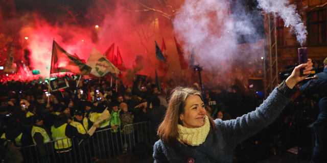 Vice-chairperson of Momentum party Anna Donath holding up a smoke grenade during an anti-government protest in downtown Budapest on Sunday. (Balazs Mohai/MTI via AP)
