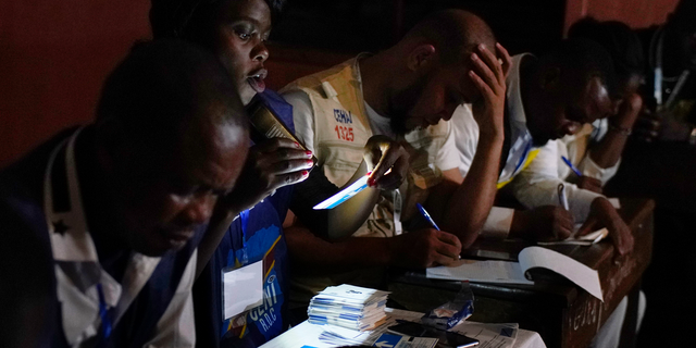 Electoral commission officials tally the presidential ballots in Kinshasa, Sunday Dec. 30, 2018. Forty million voters were registered for a presidential race plagued by years of delay and persistent rumors of lack of preparation. (AP Photo/Jerome Delay)