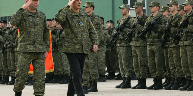 Kosovo president Hashim Thaci, center, flanked by KSF Commander Rrahman Rama as they inspect members of Kosovo Security Force in capital Pristina, Kosovo, on Thursday, Dec. 13, 2018. Kosovo lawmakers are set to transform the Kosovo Security Force into a regular army, a move that significantly heightened tension with neighboring Serbia. (AP Photo/Visar Kryeziu)