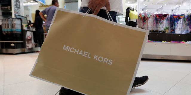 FILE- In this Nov. 23, 2018, file photo a shopper walks through Dolphin Mall while shopping on Black Friday in Miami. On Friday, Dec. 14, the Commerce Department releases U.S. retail sales data for November. (AP Photo/Lynne Sladky, File)