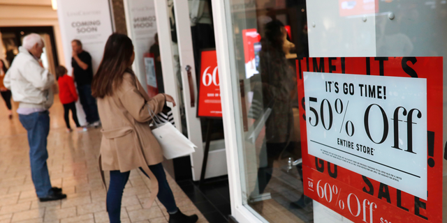 FILE - In this Dec. 24, 2018, file photo, discount placards stand in the window of a clothing store as last-minute shoppers finish up their Christmas gift lists at the Cherry Creek Mall in Denver. Americans buoyed by a strong economy pushed holiday sales growth to a six-year high. (AP Photo/David Zalubowski, File)
