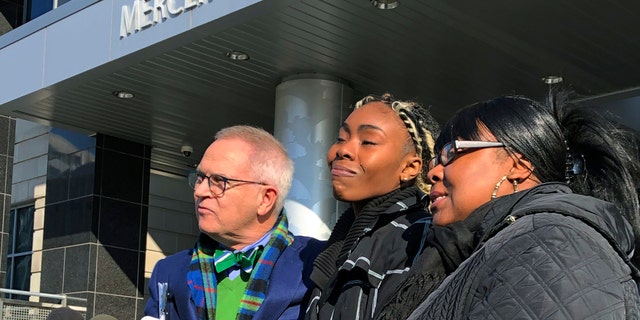 FILE - In this Dec. 12, 2018, file photo, Jazmine Headley, center, joins attorney Brian Neary and her mother, Jacqueline Jenkins, outside a courthouse in Trenton, N.J., after she accepted a deal to enter a pretrial intervention program related to credit card theft charges she faced. Headley, who had her toddler yanked from her arms by New York police in a widely seen video said in an interview published on Sunday that she went into "defense mode." (AP Photo/Mike Catalini, File)