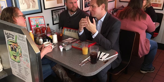 Congressman Eric Swalwell speaks with two New Hampshire Democratic state representatives at the Red Arrow Diner in Manchester.