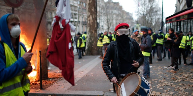 Crowds of yellow-vested protesters angry at President Emmanuel Macron and France's high taxes tried to converge on the presidential palace Saturday, some scuffling with police firing tear gas, amid exceptional security measures aimed at preventing a repeat of last week's rioting