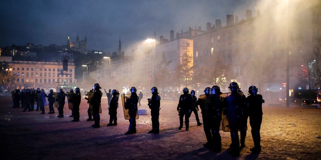 Police officers face demonstrators in Lyon, central France, Saturday, Dec. 8, 2018. The grassroots movement began as resistance against a rise in taxes for diesel and gasoline, but quickly expanded to encompass frustration at stagnant incomes and the growing cost of living. (AP Photo/Laurent Cipriani)