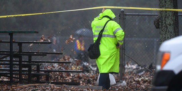 An investigator works the scene of a small plane crash in a city park which killed all on board, Thursday, Dec. 20, 2018, in northwest Atlanta.