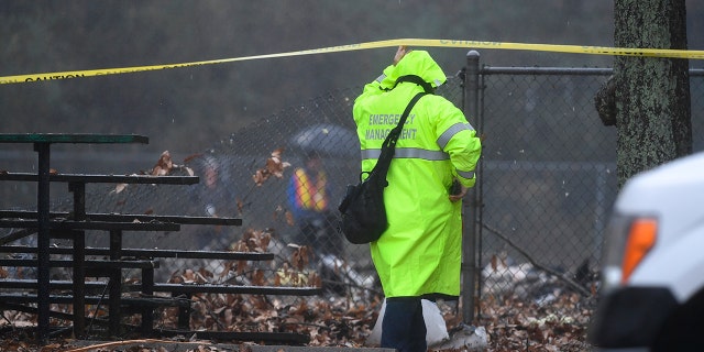 An investigator works the scene of a small plane crash in a city park which killed all on board, Thursday, Dec. 20, 2018, in northwest Atlanta.