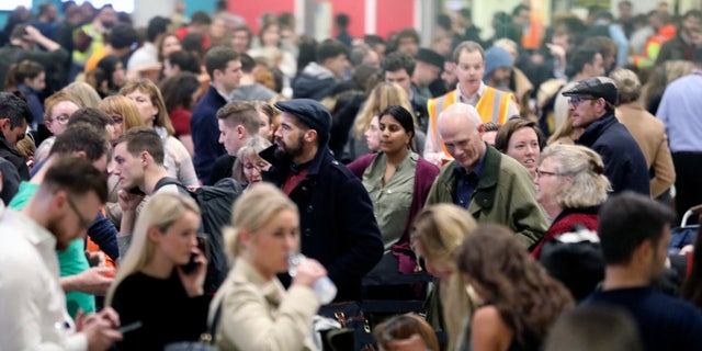 Passengers wait for flights at Gatwick Airport Friday. (John Stillwell/PA via AP)