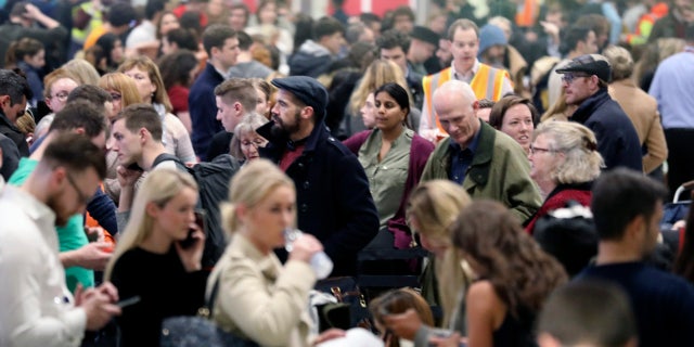 Passengers wait for flights at Gatwick Airport Friday. (John Stillwell/PA via AP)