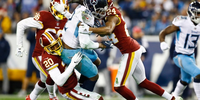 Derrick Henry, No. 22, of the Tennessee Titans is tackled by Josh Norman, No. 24, of the Washington Redskins and Ha Ha Clinton-Dix, No. 20, during the third quarter at Nissan Stadium on Dec. 22, 2018 in Nashville. (Getty Images)