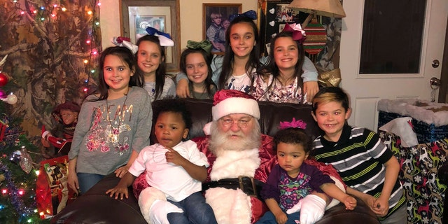 All but one of the Hawthorn's adopted kids pose with Santa as they will all be celebrating Christmas as one family this year.