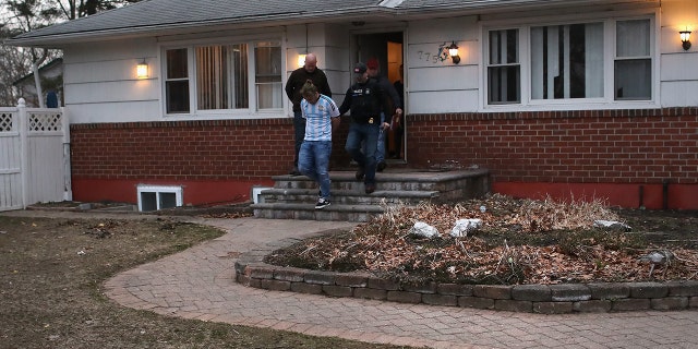 ICE agents detain a suspected MS-13 gang member and Honduran immigrant at his home in  Brentwood, N.Y., in March.