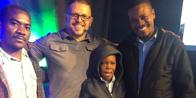 Pastor Paul Boutan of Calvary Chapel Brighton in Colorado poses with "Little John," his father, Jean Olivier, and their translator, Luccone Lucce Sunday following a successful surgery in Connecticut.