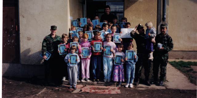 Mine strikes in post-war Bosnia was very high among children. Chad Storlie's team "adopted" a small village in central Bosnia and we brought coloring books, markers, paper, and other supplies to their school. This is in 1996, a Romanian soldier is second from the right. (Courtesy of the author)