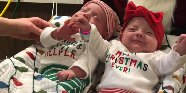 Two babies posing in their festive outfits.