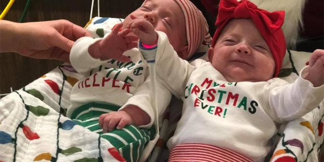 Two babies posing in their festive outfits.