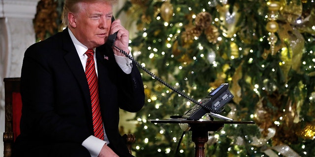 President Donald Trump speaks on the phone sharing updates to track Santa's movements from the North American Aerospace Defense Command (NORAD) Santa Tracker on Christmas Eve, Monday, Dec. 24, 2018. (AP Photo/Jacquelyn Martin)
