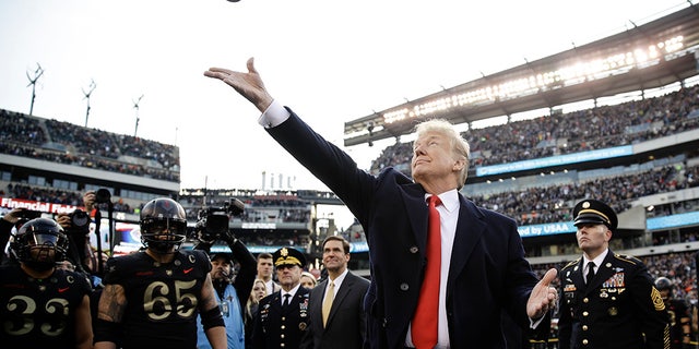 President Donald Trump tosses the coin before the Army-Navy NCAA college football Saturday, Dec. 8, 2018, in Philadelphia. (AP Photo/Matt Rourke)
