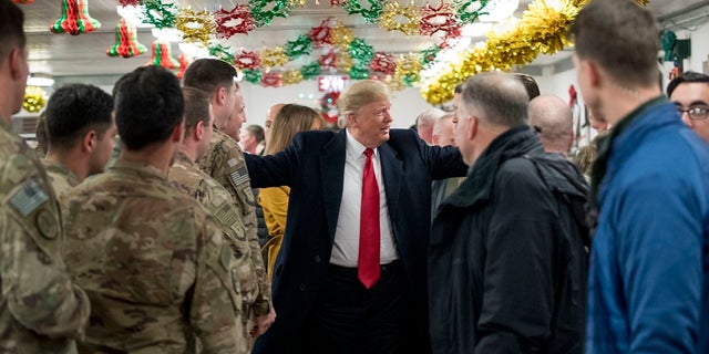 President Donald Trump visits with members of the military at a dining hall at Al Asad Air Base, Iraq, Wednesday, Dec. 26, 2018. (AP Photo/Andrew Harnik)