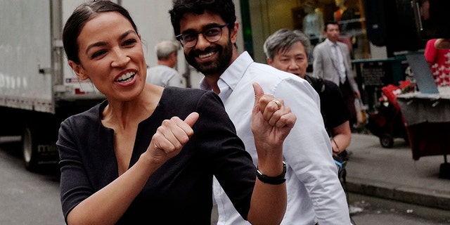 FILE - In this Wednesday June 27, 2018, file photo, Alexandria Ocasio-Cortez, left, the winner of New York's Democratic Congressional primary, greets supporters following her victory, along with Saikat Chakrabarti, founder of Justice Democrats and senior adviser for her campaign. (AP Photo/Mark Lennihan, File)