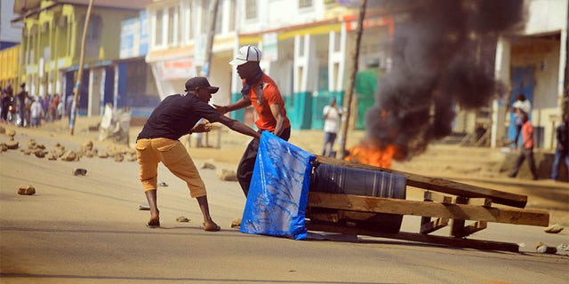 Protesters set up a barricade in the Eastern Congolese city of Beni on Thursday. Police in eastern Congo have fired live ammunition and tear gas to disperse dozens of people protesting a presidential election delay that means more than 1 million votes will not count.