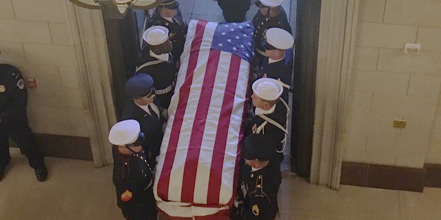 A military honor guard marches the casket of former President George H.W. Bush into the U.S. Capitol on Monday.