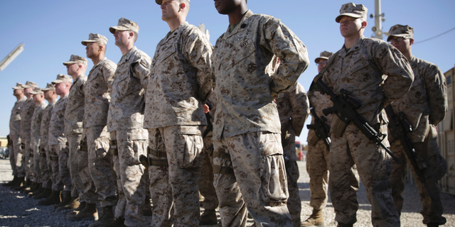 FILE - In this Jan. 15, 2018 file photo, U.S. Marines stand guard during the change of command ceremony at Task Force Southwest military field in Shorab military camp of Helmand province, Afghanistan. The Pentagon is developing plans to withdraw up to half of the 14,000 American troops serving in Afghanistan, U.S. officials said Thursday, Dec. 20, 2018, marking a sharp change in the Trump administration's policy aimed at forcing the Taliban to the peace table after more than 17 years of war. (AP Photo/Massoud Hossaini, File)