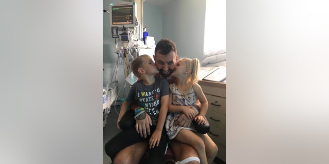 Braham, pictured with his two children while recovering.