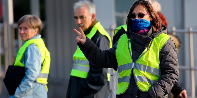 Demonstrators wearing yellow vests protest at the toll gates of a motorway, in Biarritz, southwestern France, Monday, Dec. 10, 2018.