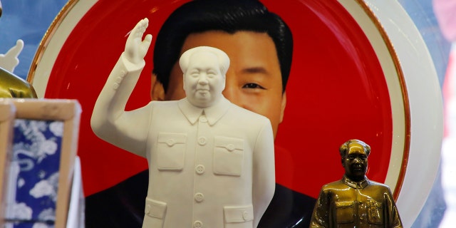 Sculptures of the late Chinese Chairman Mao Zedong are placed in front of a souvenir plate featuring a portrait of Chinese President Xi Jinping at a shop next to Tiananmen Square in Beijing, China, March 1, 2018. REUTERS/Jason Lee - RC19877D4F20