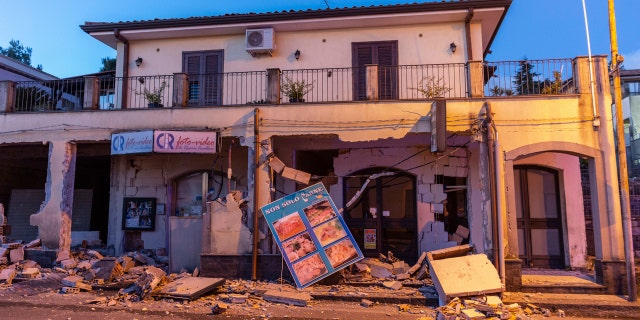 Debris sits on the street in front of a heavily damaged house in Fleri, Sicily Italy, Wednesday, Dec. 26, 2018.
