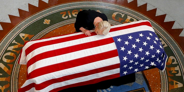 Cindy McCain, wife of, Sen. John McCain, R-Ariz. lays her head on casket during a memorial service at the Arizona Capitol on Wednesday, Aug. 29, 2018, in Phoenix. (AP Photo/Ross D. Franklin, Pool)