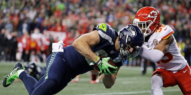 Seattle Seahawks tight end Nick Vannett, left, dives past Kansas City Chiefs cornerback Charvarius Ward, right, for a touchdown during the first half of an NFL football game, Sunday, Dec. 23, 2018, in Seattle. (Associated Press)