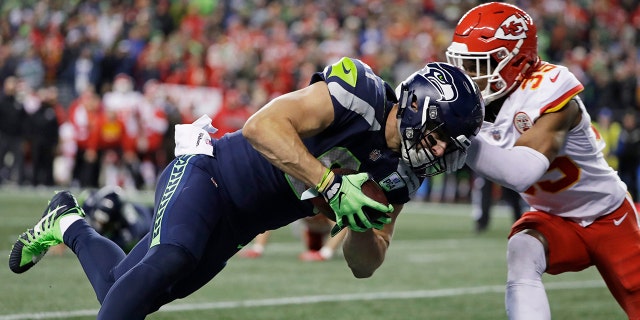 Seattle Seahawks tight end Nick Vannett, left, dives past Kansas City Chiefs cornerback Charvarius Ward, right, for a touchdown during the first half of an NFL football game, Sunday, Dec. 23, 2018, in Seattle. (Associated Press)