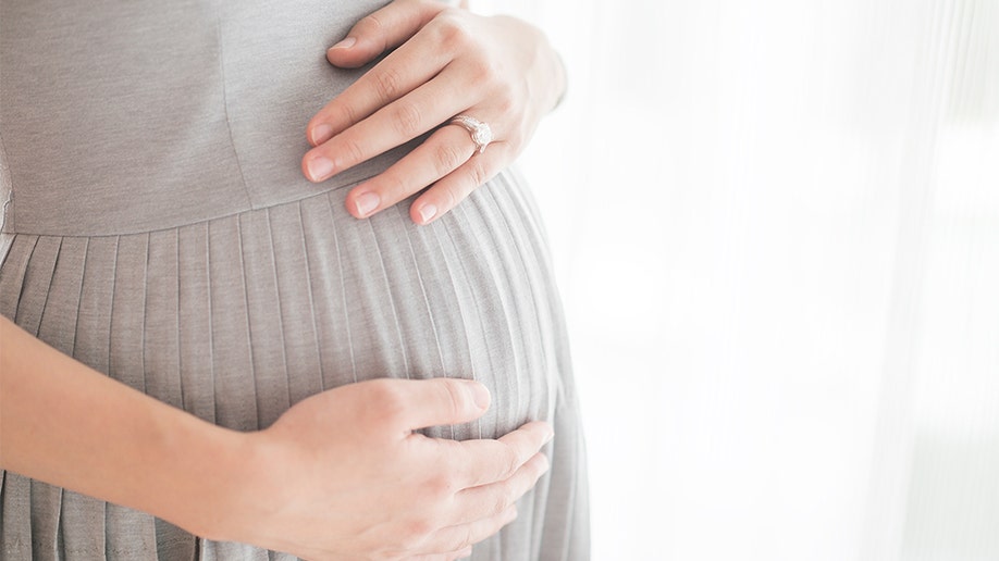 Photo of woman holding pregnant belly