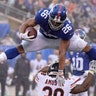 New York Giants running back Saquon Barkley leaps over Chicago Bears strong safety Adrian Amos during an NFL football game in East Rutherford, Dec. 2, 2018. 