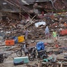 People inspect the damage at a tsunami-ravaged village in Sumur, Indonesia, Dec. 25, 2018. 