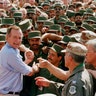 In this Nov. 22, 1990 file photo, President George H.W. Bush is greeted by Saudi troops and others as he arrives in Dhahran, Saudi Arabia, for a Thanksgiving visit. 