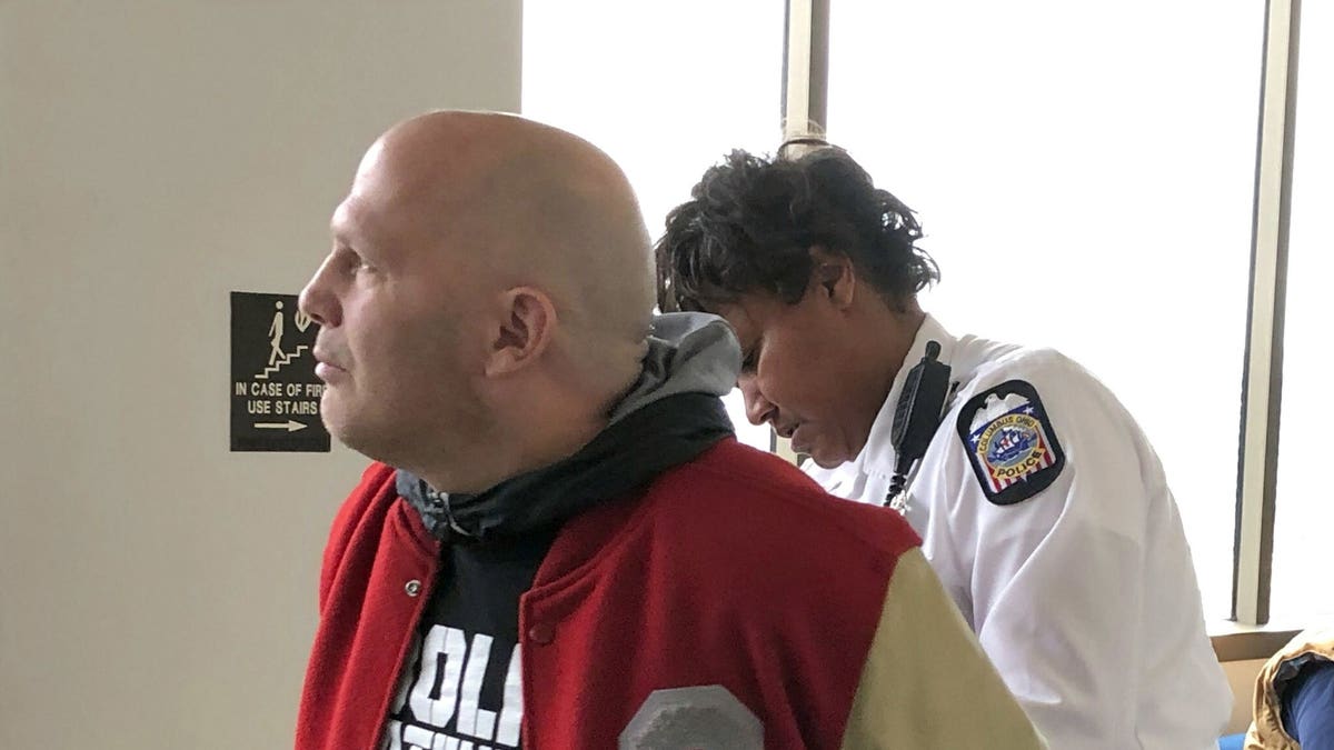 Mike DiSabato, left, turns himself in for arrest by an officer at Franklin County Municipal Court in Columbus, Ohio, on Monday, Jan. 7, 2019. 