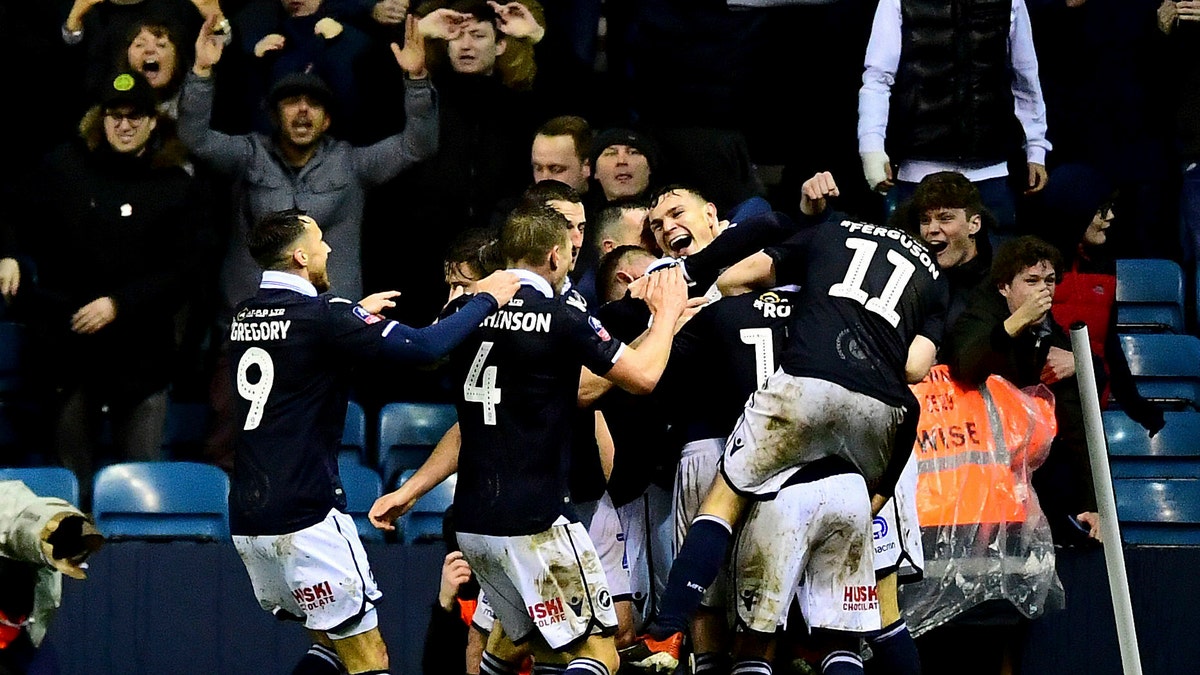 Millwall's Jake Cooper, centre, celebrates scoring his side's second goal of the game against Everton during their English FA Cup fourth round soccer match at The Den in London, Saturday Jan. 26, 2019.