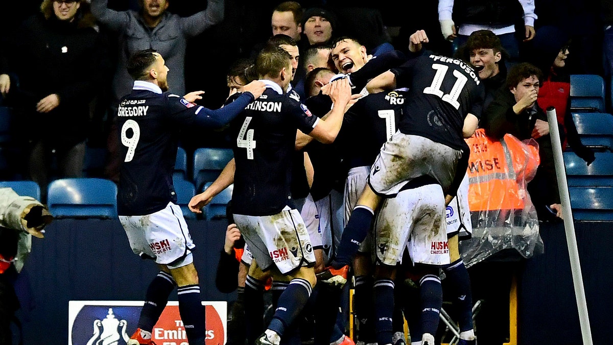 Millwall's Jake Cooper, centre, celebrates scoring his side's second goal of the game against Everton during their English FA Cup fourth round soccer match at The Den in London, Saturday Jan. 26, 2019.