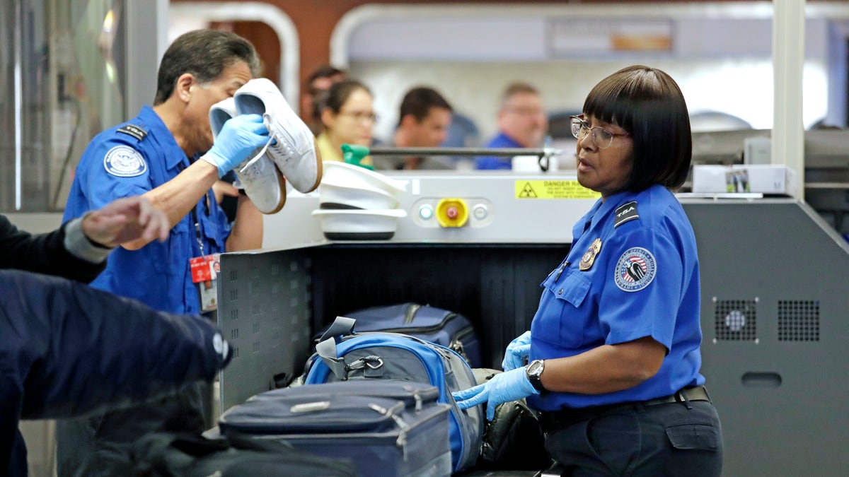 Transportation Security Administration (TSA) officers assist travelers with luggage through a security screening area during a partial federal government shutdown Monday, Dec. 31, 2018, at Seattle-Tacoma International Airport in Washington state. (Associated Press)